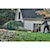 21 and a half inch Brushless Cordless Self Propelled mower being used by a person on the lawn of a house